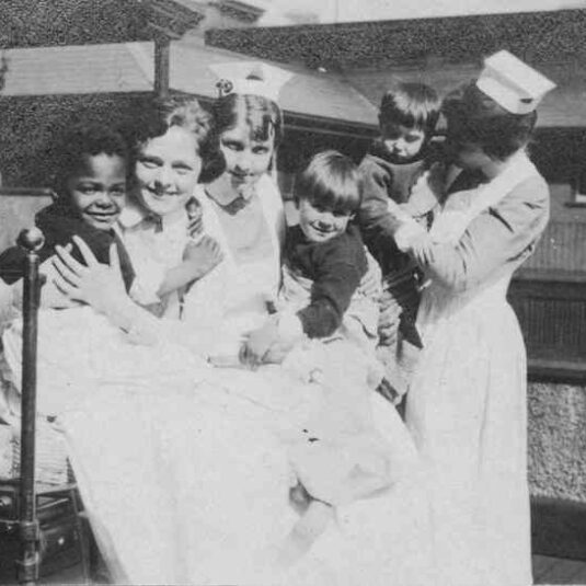 nurses holding children in ward